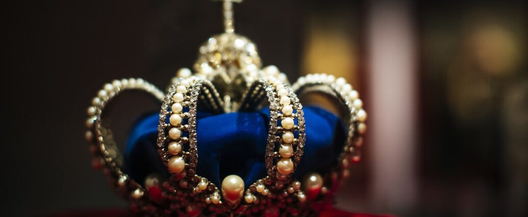 navy and gold crown on red velvet cushion. The Crown.