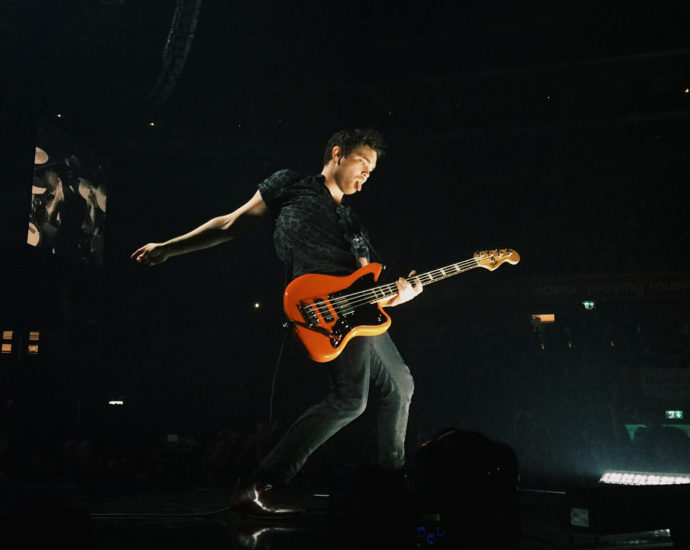 Royal Blood's guitarist Mike Kerr playing a guitar on stage