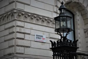 The street sign that reads "Downing Street SW1" on the wall of a building