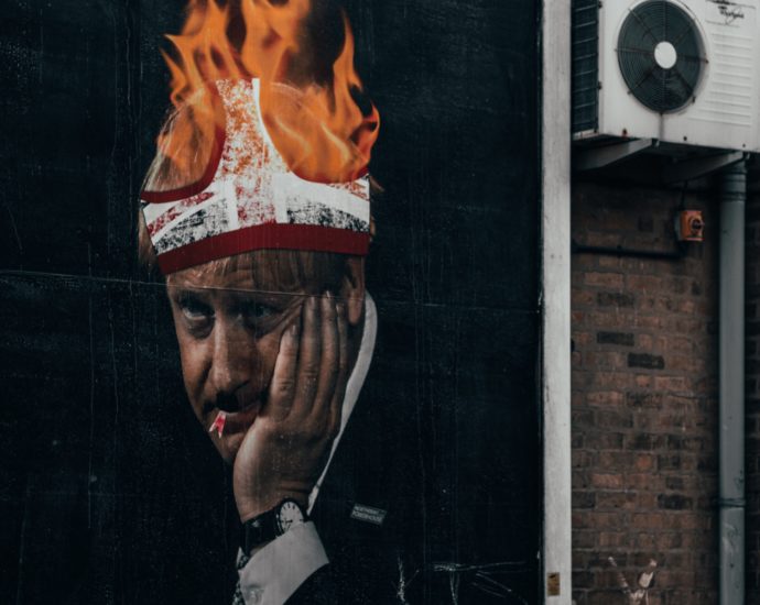 billboard image showing boris johnson with pants on fire on his head