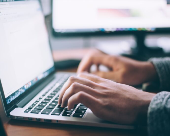 Hands typing on laptop keyboard