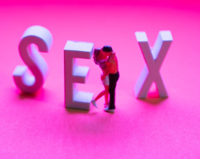 Pink background with the word 'sex' and two people kissing