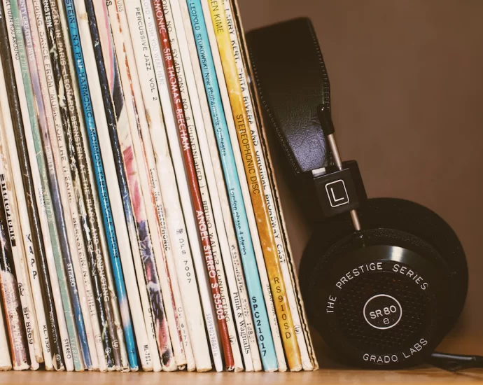 records resting on a shelf next to a pair of headphones