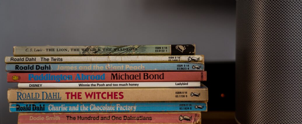 A stack of Roald Dahl books lying down on a shelf.