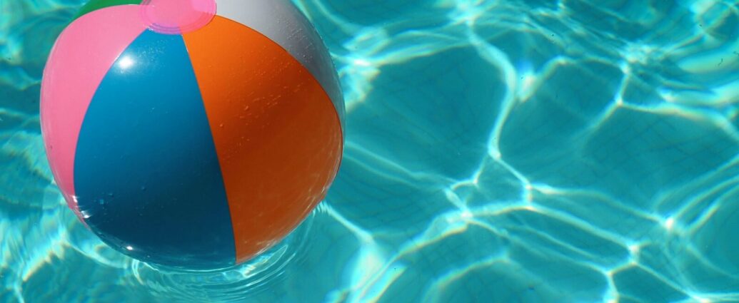 Beach ball in a clear blue swimming pool