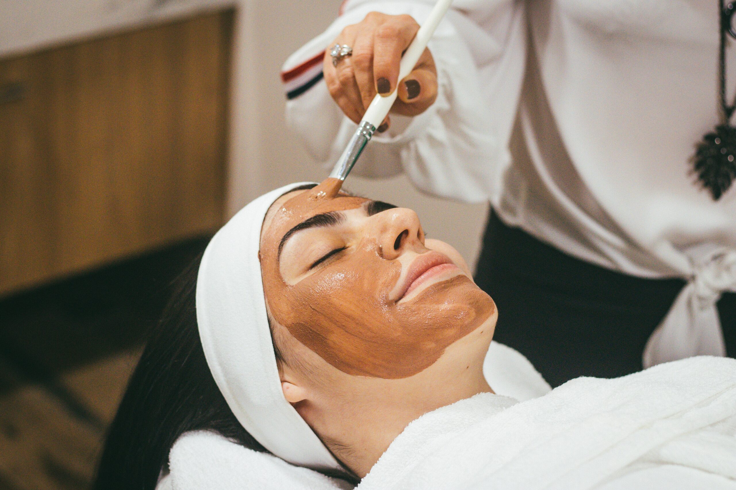 woman having face mask applied at spa
