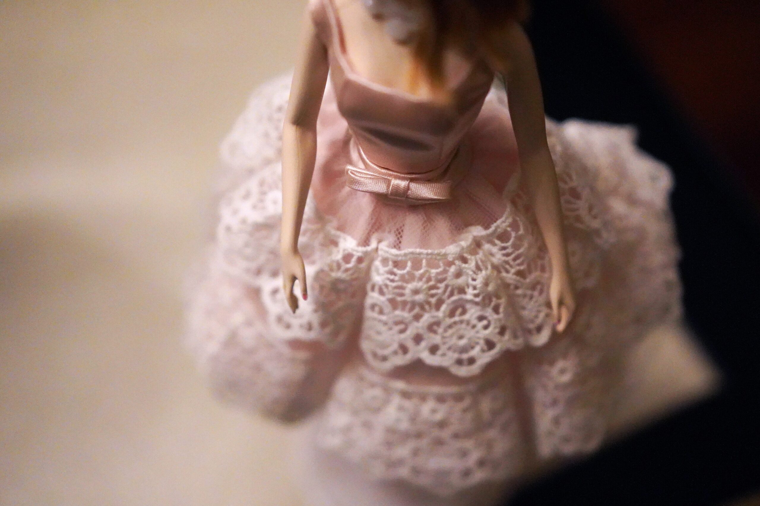 A fashion doll wearing a pink tutu-style dress, replicating the femininity and style of Barbie.