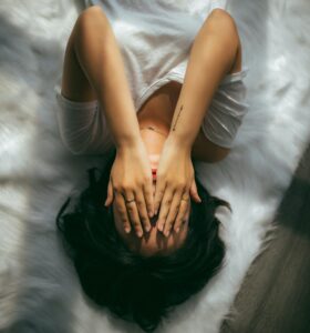 Woman stressed lying on a bed.