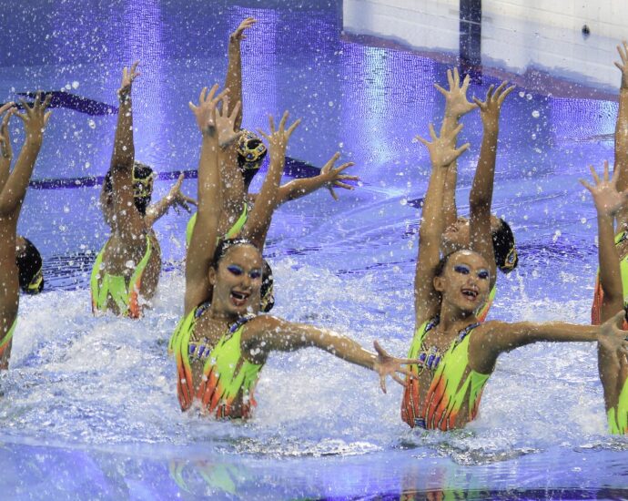 a team of young women completing an artistic swimming performance