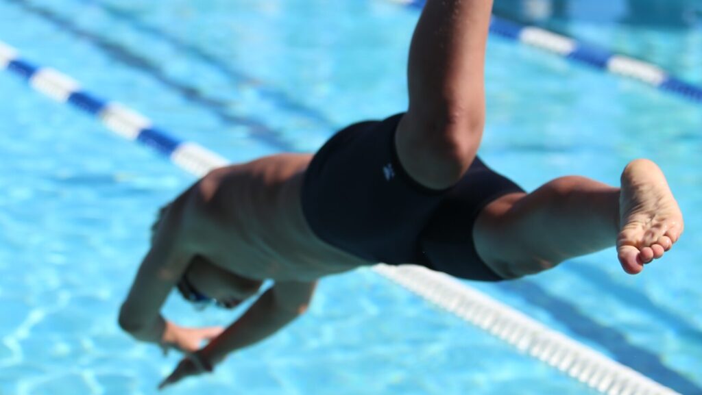 person diving into a swimming pool.