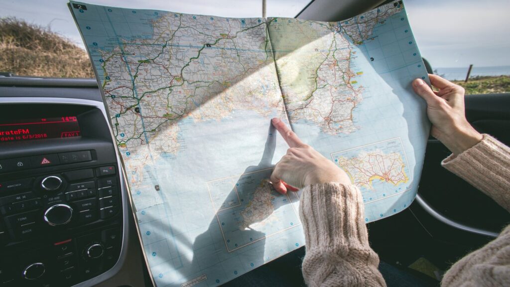 A person pointing at a map with their index finger. Empoword's travel tips and tricks.