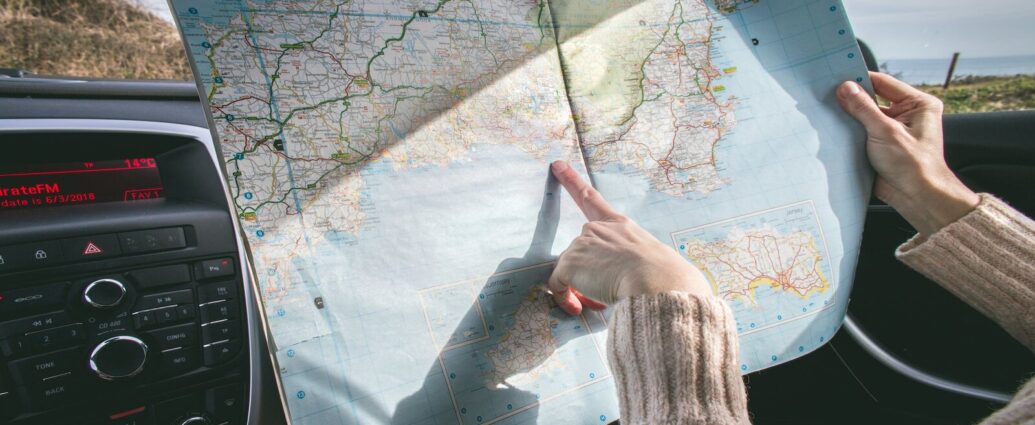 A person pointing at a map with their index finger. Empoword's travel tips and tricks.