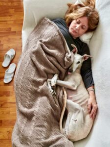 Woman sleeping next to her dog
