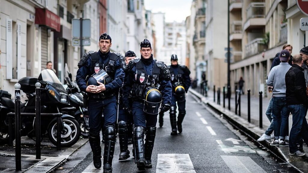 Armed police officers walk down an alley in France