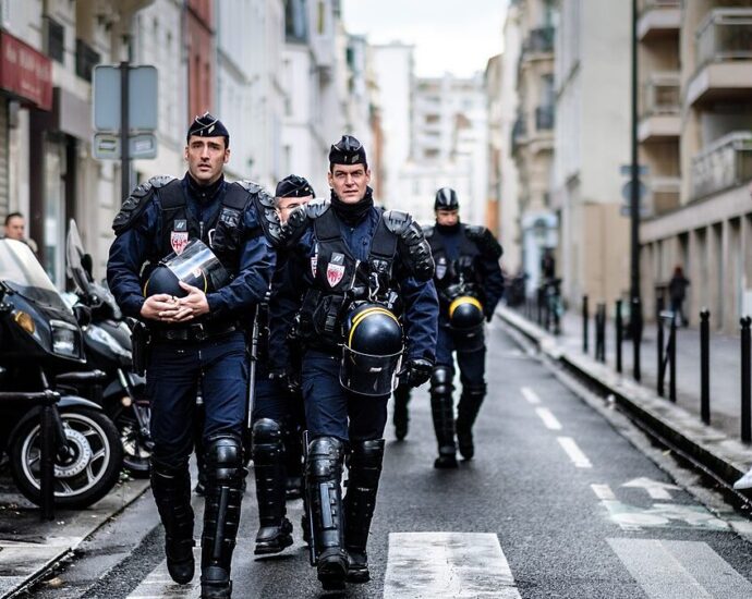 Armed police officers walk down an alley in France