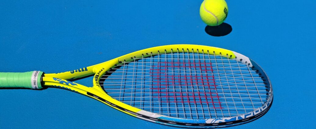 Tennis racket and ball on blue court