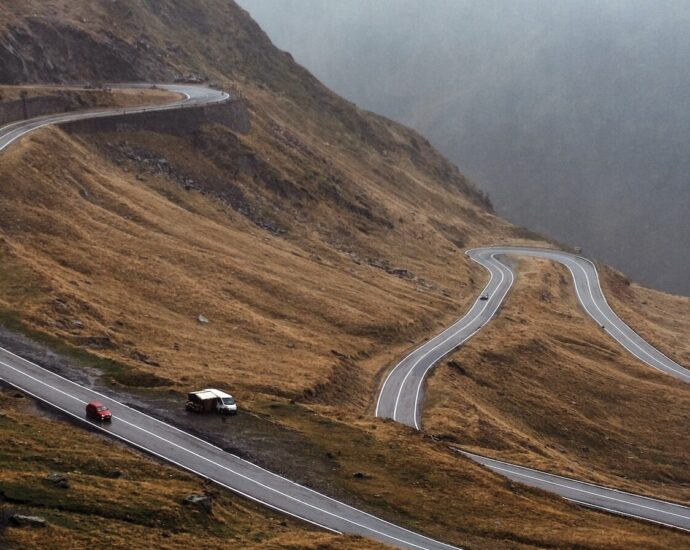 A winding road on a hillside in Romania.