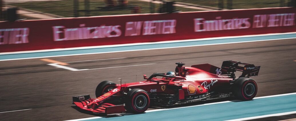 Charles Leclerc's ferrari racing down a straight on a formula one track