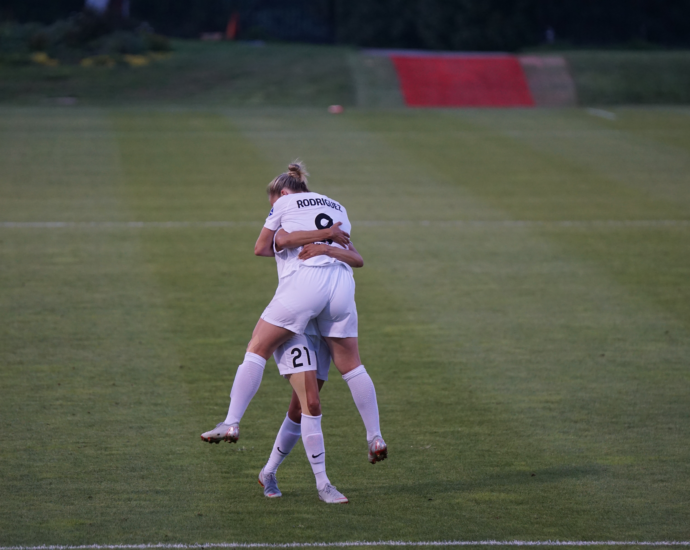 two England lionesses celebrating on the pitch