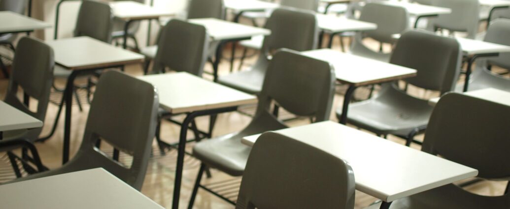 Image of chairs and desks lined up in a school hall.