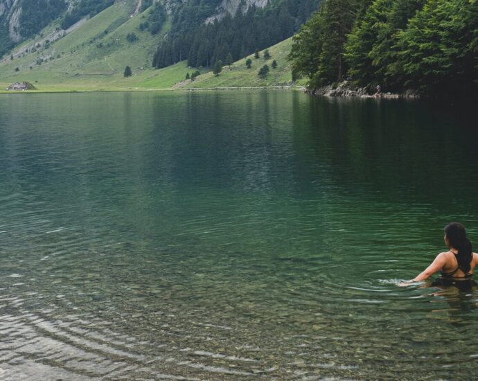 Image shows a woman cold water swimming in a lake