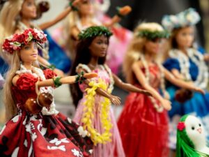 Image shows five Barbies in colourful dresses and flower crowns