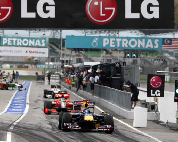 Image shows cars racing beneath an LG banner at the Grand Prix.