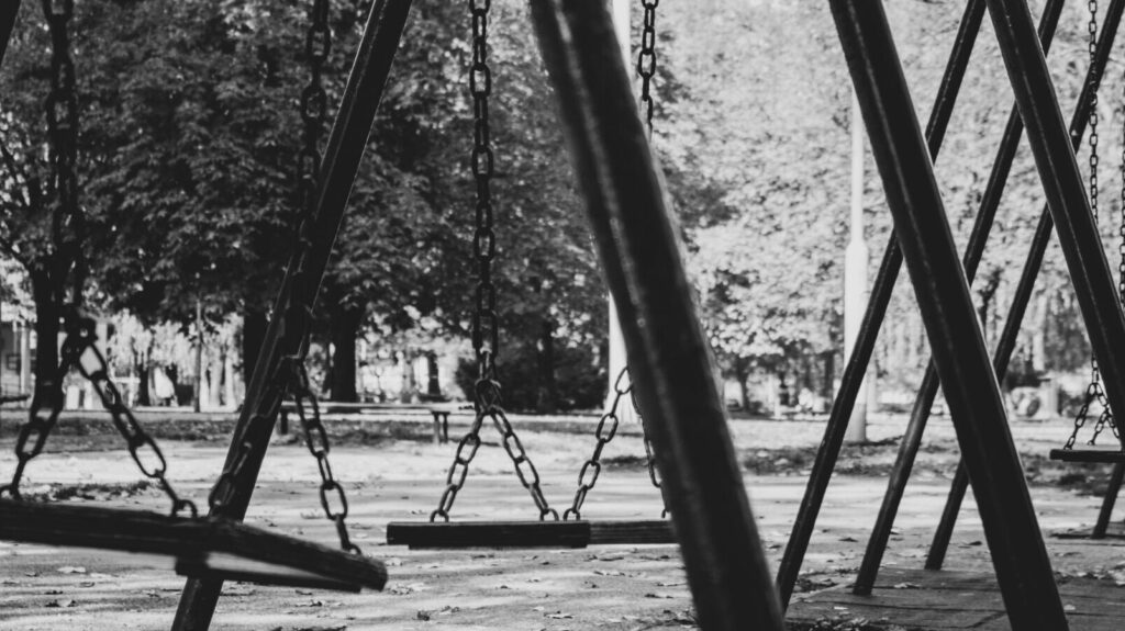 Empty swing set in black and white.