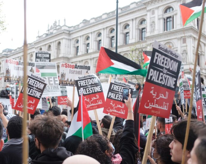 Israel-Palestine conflict. Citizens hold signs protesting the occupation of Palestine