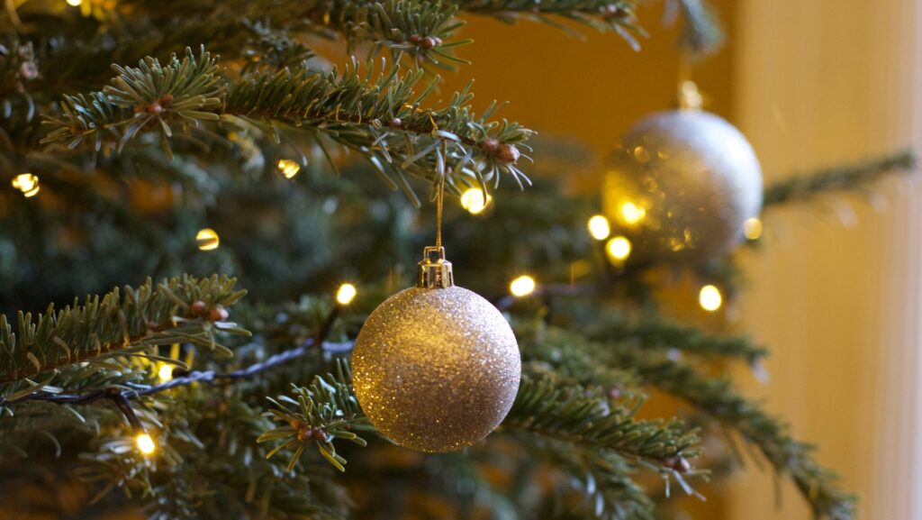 Christmas tree decorated with lights and gold baubles.