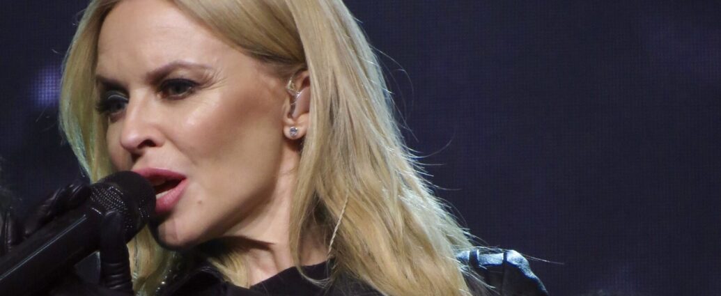 Blonde Kylie Minogue sings passionately into microphone
