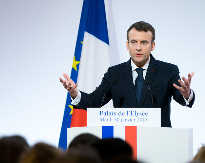 President Macron delivers a speech at a lectern.
