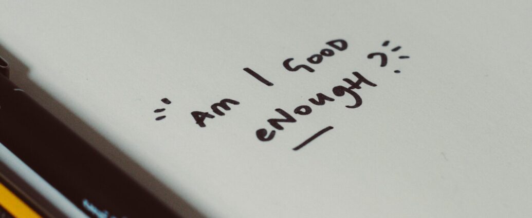 Image shows a piece of paper with the words 'Am I good enough?' on it [self-optimisation]