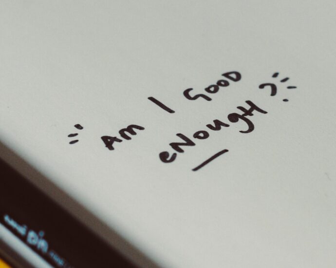 Image shows a piece of paper with the words 'Am I good enough?' on it [self-optimisation]