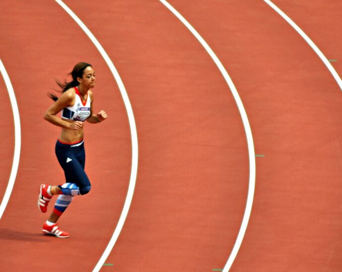 Image shows athlete Katarina Johnson-Thompson running across a track.