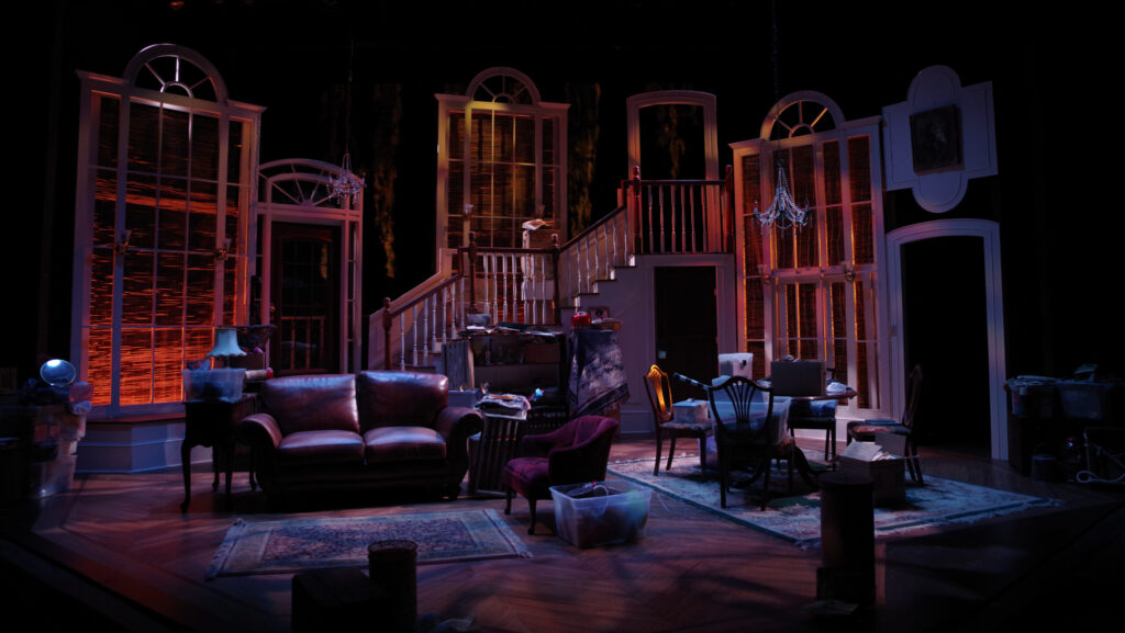 Living room set on stage with sofa, furniture and low lighting.