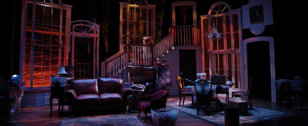 Living room set on stage with sofa, furniture and low lighting.