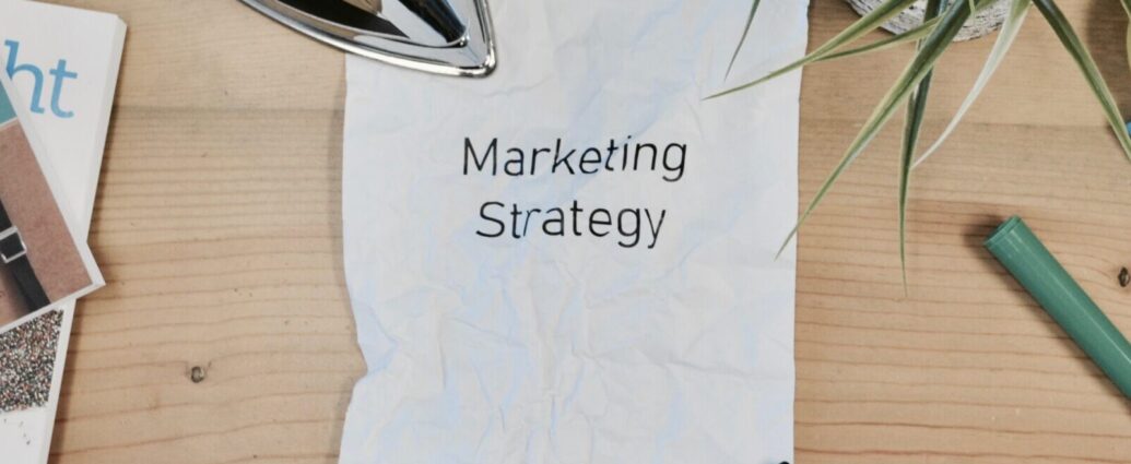 Image shows a piece of paper on a desk with the words 'marketing strategy' printed onto it [FOMO marketing]