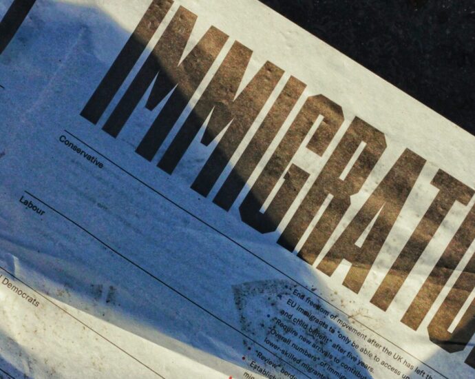 Newspaper with headline 'IMMIGRATION', portraying asylum seekers rhetoric.