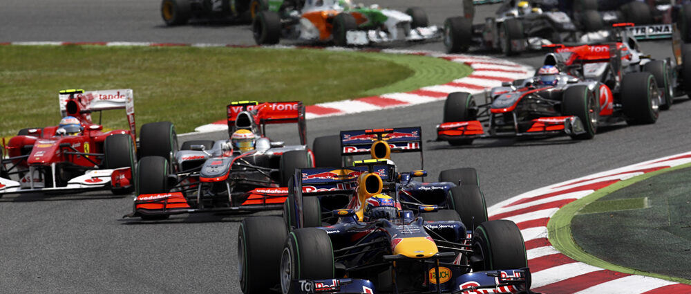 Image shows formula 1 cars on a track.