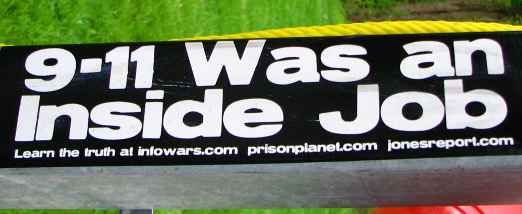 Image shows a sticker that reads '9/11 was an inside job' [conspiracy theories]