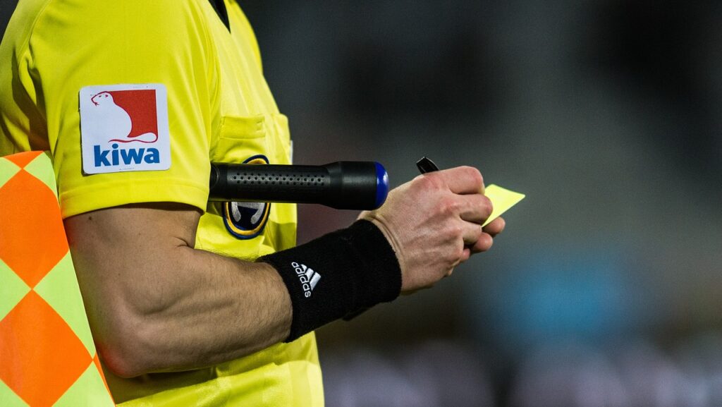 Referee issuing a yellow card in a football game