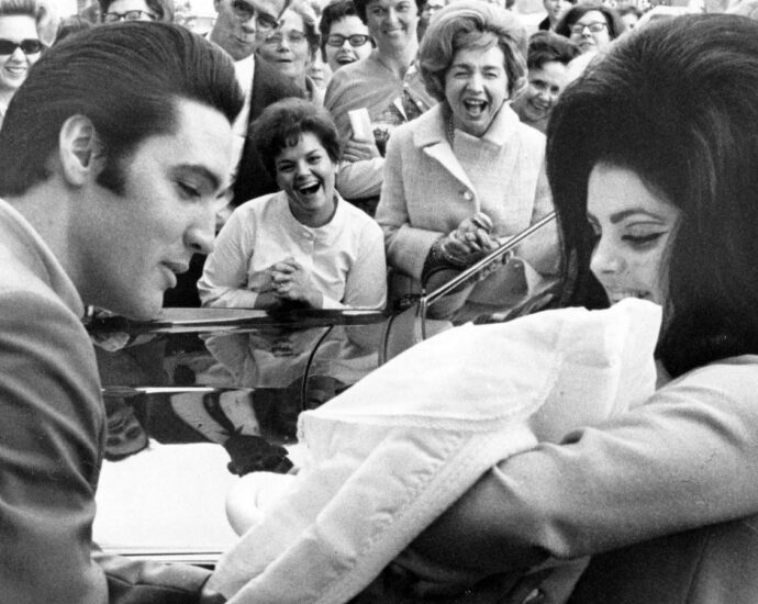 Black and white image of Elvis Presley and Priscilla with Lisa Marie, February 1968
