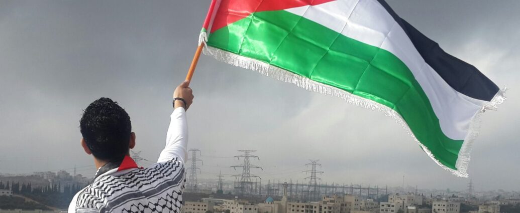 Image of man holding Palestinian flag.