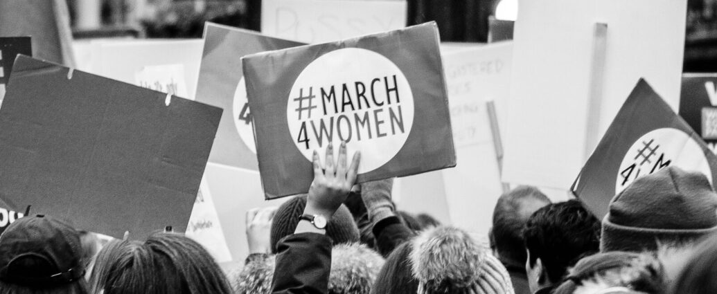 Image shows a protest placard that reads 'March 4 Women' [Women's History Month]