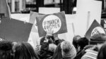 Image shows a protest placard that reads 'March 4 Women' [Women's History Month]