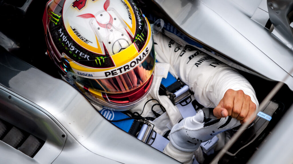 Image shows Lewis Hamilton in the driver's seat of his Mercedes F1 car.