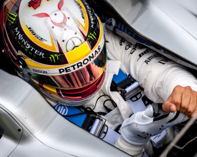 Image shows Lewis Hamilton in the driver's seat of his Mercedes F1 car.