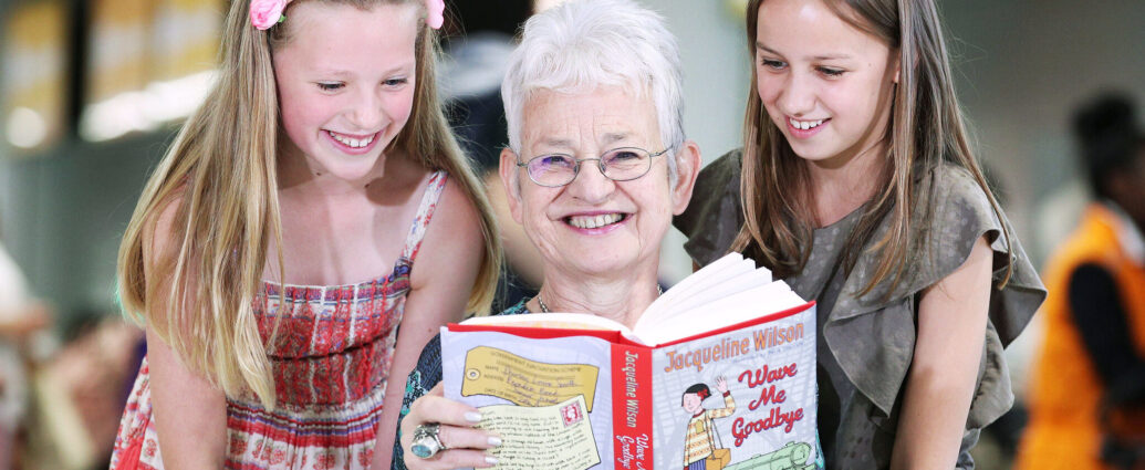 Jacqueline Wilson holding a book smiling