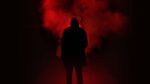 A shadowy figure stands in front of a red fog. Why are some of the "red-pilled" commentators of the "manosphere" women?